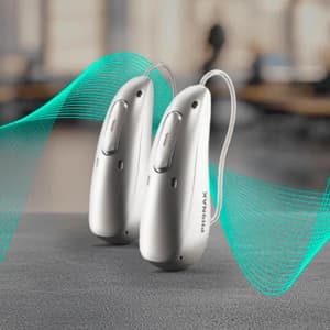 Aparelhos auditivos em destaque sobre superfície neutra.